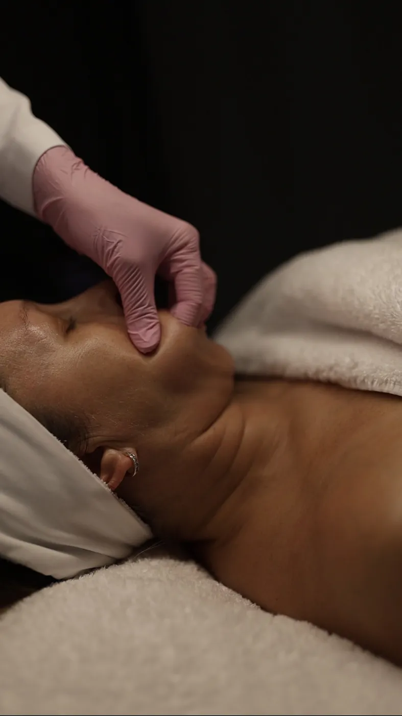 Gloved work along the jawline and down the neck at the finish of a buccal massage appointment